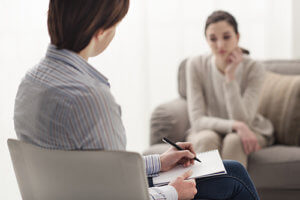 a woman talks with a counselor about substance abuse treatment