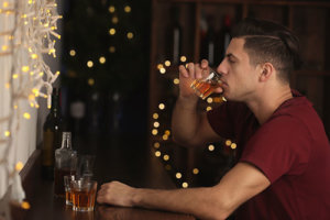 young man participating in binge drinking on college campuses