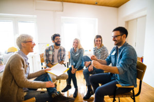 a group therapy session discussing the benefits of cognitive behavioral therapy