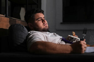 young man with a cake wonders how to stop binge eating disorder