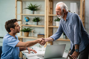 senior man shakes hands with young male therapist in an avoidant personality disorder treatment center