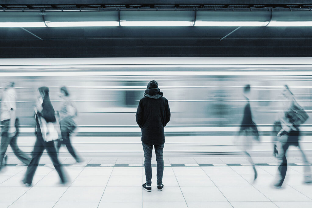 a person stands in a busy subway station wondering how to cope with loneliness
