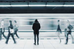 a person stands in a busy subway station wondering how to cope with loneliness