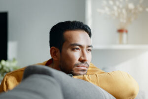 a young man looks sad after researching signs of anxiety in men