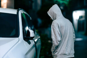 a hooded young man approaches a car, thinking about what is angel dust