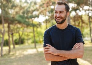 a young man smiles outside at a bipolar disorder treatment program