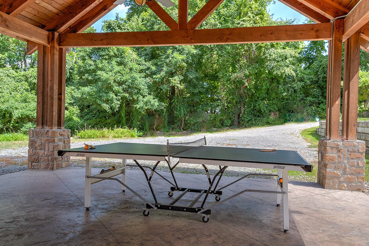 a ping pong table on a covered patio near a driveway