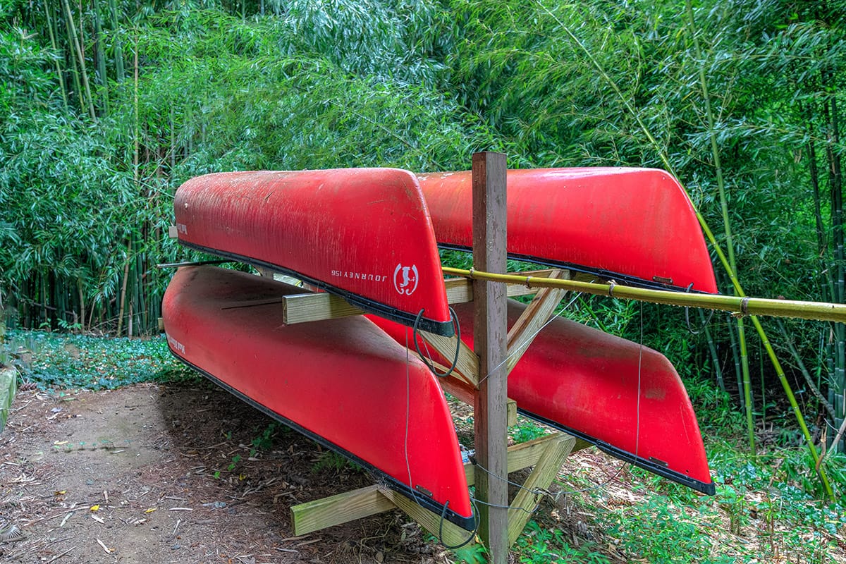 four red canoes on a rack