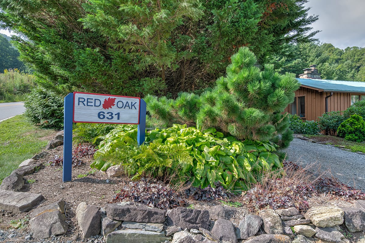 a cabin near a driveway sign that reads "Red Oak 631"