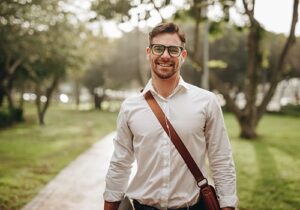 a young man stands on a driveway smiling after completing a depression treatment program