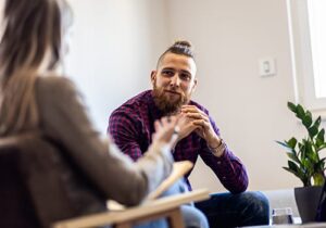 a young man talks with a counselor in a prescription drug addiction treatment center