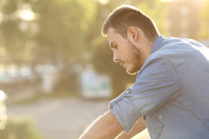 A man looks troubled while wondering, "is alcohol a drug?"