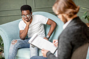 a young man listens to a therapist in a mood disorder treatment program