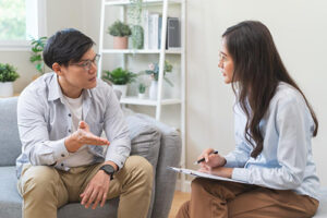 a young man talks to a therapist in a trauma treatment program