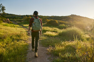 a young man hikes a trail in an adventure therapy program