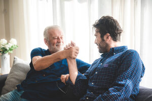 an older parent and younger man shake hands in a family therapy program