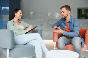 a man talks to a therapist during a recovery management program