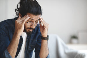 a man sits and rubs his head after stopping alcohol cold turkey