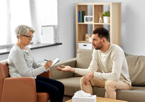 a man talks to a therapist during dual diagnosis treatment