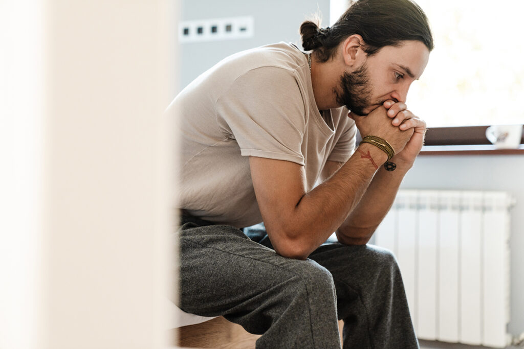 a man struggling with kratom addiction sits and thinks