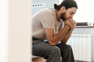 a man struggling with kratom addiction sits and thinks